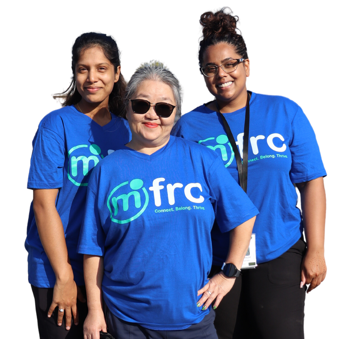 3 diverse female-presenting MFRC employees smiling wearing their blue 2023 MFRC Walk-a-thon t-shirts.